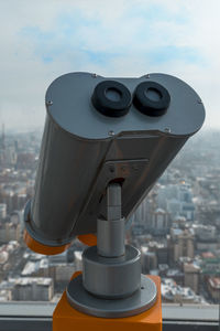 Close-up of coin-operated binoculars against sky