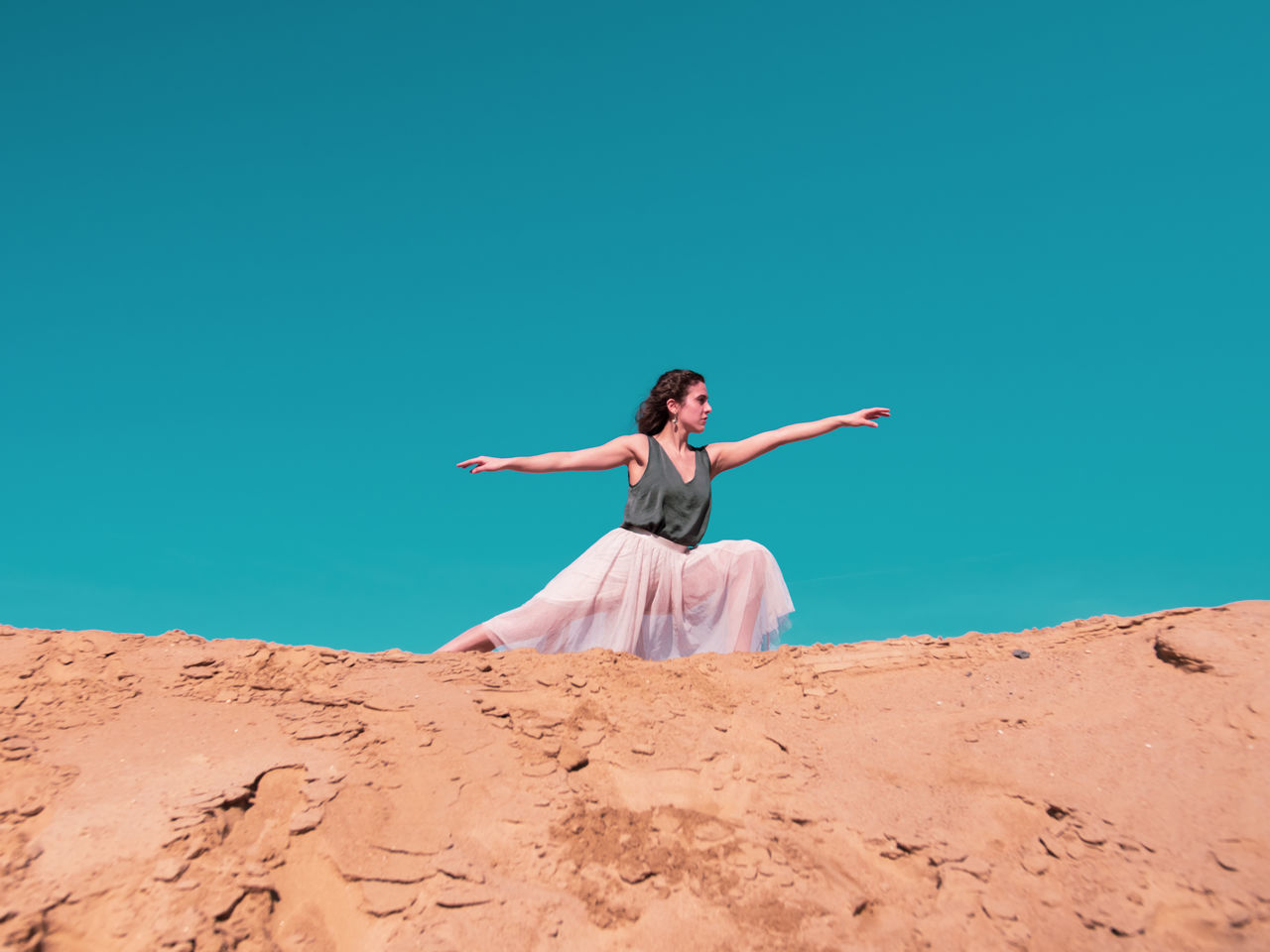 FULL LENGTH OF WOMAN WITH ARMS RAISED AGAINST CLEAR SKY