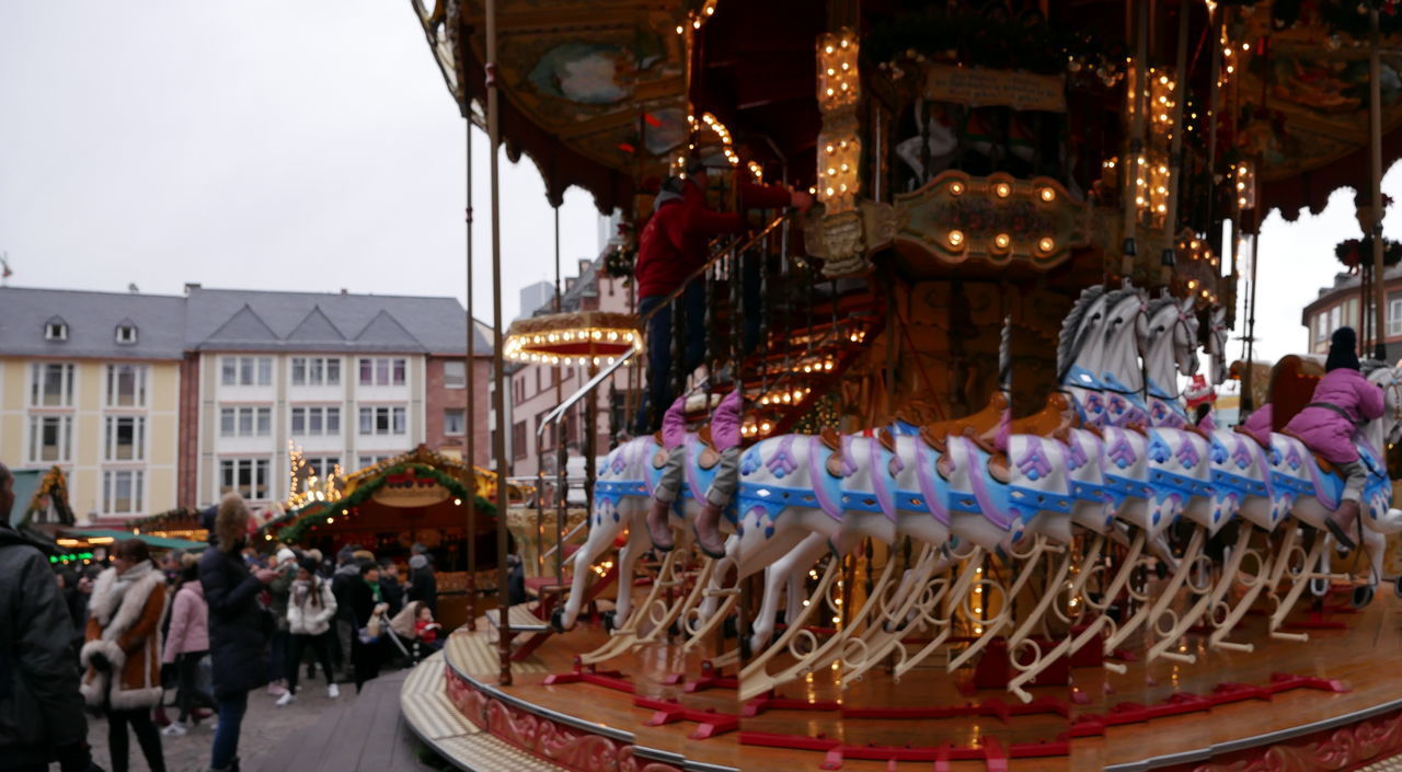 CROWD AT AMUSEMENT PARK IN CITY