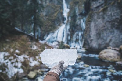 Close-up of hand holding rock in river