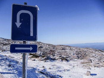 Road sign against clear blue sky