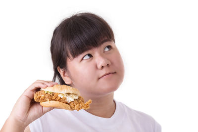 Portrait of boy holding ice cream against white background