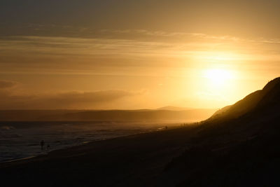 Scenic view of beach against sky during sunset