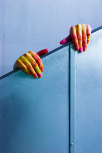 Cropped messy hands holding railing against wall