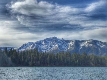 Scenic view of lake by mountains against sky