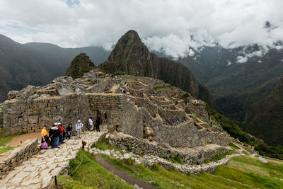 People walking on mountain against sky