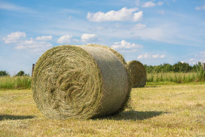 Hay bales on field against sky