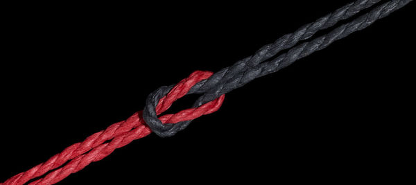 Close-up of rope tied up on black background