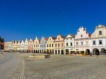 Buildings in city against clear blue sky