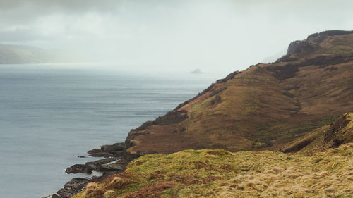 Scenic view of sea and mountains against sky