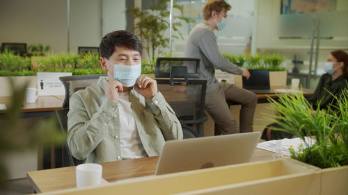 Smiling businessman talking on video call at office