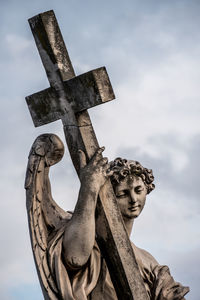 Low angle view of angel statue against sky