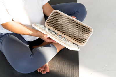 Low section of woman holding acupuncture equipment