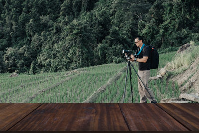 Man photographing from camera while standing by land