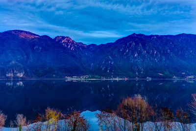 Scenic view of lake and mountains against blue sky