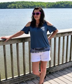 Full length of young woman standing by railing