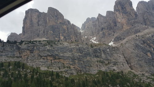 Low angle view of rocky mountains against sky