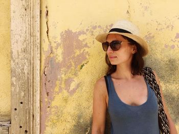 Portrait of beautiful young woman wearing sunglasses standing outdoors