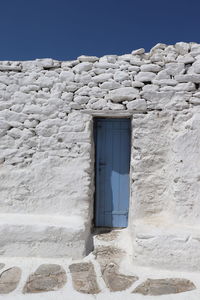 Closed door of building against blue sky