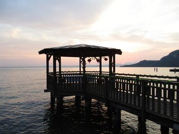 Pier over sea against sky during sunset