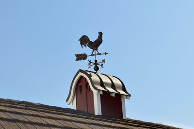 Low angle view of weather vane on roof