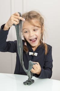 Portrait of a smiling girl holding table