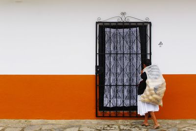 Rear view of woman against wall