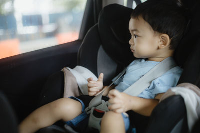 Asian boy sitting in car seat