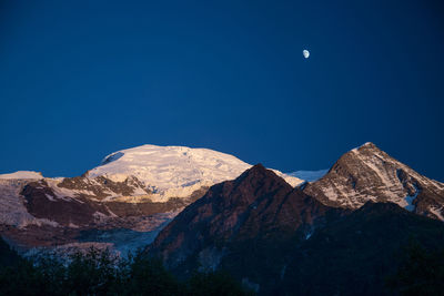 Scenic view of mountains against blue sky