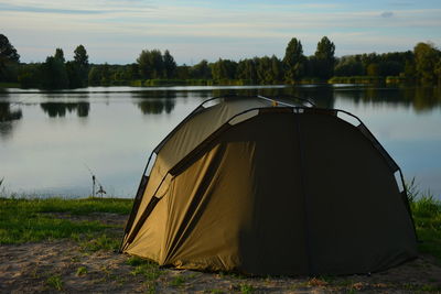 Tent by river against sky