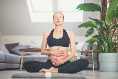 Portrait of young woman exercising at home