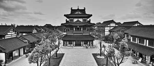 People at temple against cloudy sky