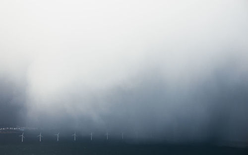 Wind mill against sky during foggy weather