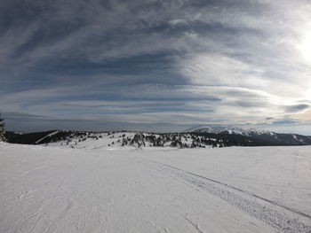 Scenic view of snow covered land against sky
