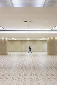 Rear view of man walking in corridor of building