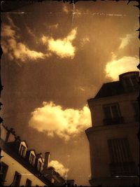 Low angle view of buildings against cloudy sky