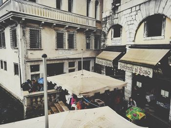 People on street amidst buildings in city