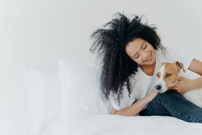 Young woman with dog on bed