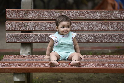 Full length of baby girl sitting on bench