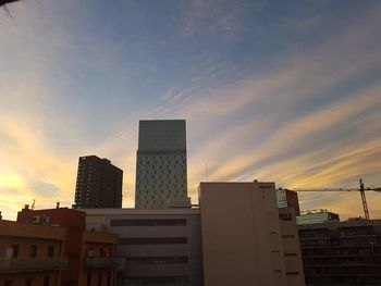 Low angle view of skyscraper against sky during sunset