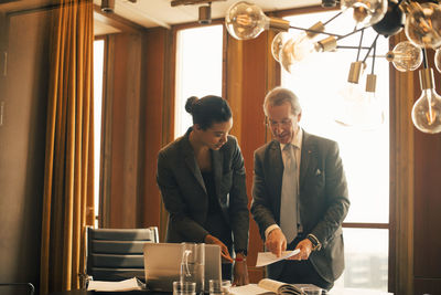 Mature legal professional explaining female colleague in meeting at board room