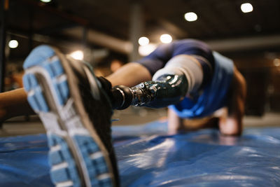 Low section of man with prosthetic legs exercising in gym