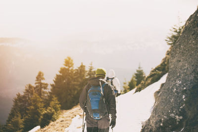 Rear view of people hiking on mountain in winter