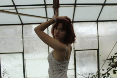 Portrait of woman standing against wall