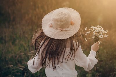 Rear view of woman with white flowers