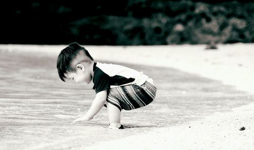 Side view of happy toddler standing on shore at beach