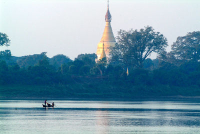 People in temple by mountain against sky