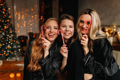 Happy funny girls celebrate christmas holidays and new year in a cozy house