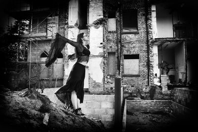 Side view of woman standing on abandoned building