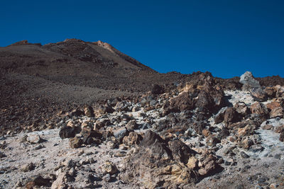 Scenic view of rocky mountains against clear blue sky